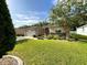 Single story home with a two car garage, lush lawn, and landscaped flower beds at 16405 Sw 14Th Avenue Rd, Ocala, FL 34473