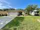 Charming one-story home features a two-car garage, manicured lawn, and beautiful landscaping at 16405 Sw 14Th Avenue Rd, Ocala, FL 34473
