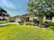 Single-story home featuring a manicured lawn, tasteful decorative accents, and mature landscaping at 16405 Sw 14Th Avenue Rd, Ocala, FL 34473