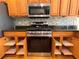 Updated kitchen features stainless steel appliances, granite counters, tile backsplash, and wood cabinets with pull out shelving at 16405 Sw 14Th Avenue Rd, Ocala, FL 34473