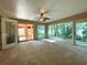Carpeted sunroom featuring multiple windows, ceiling fan, and access to other living spaces at 16405 Sw 14Th Avenue Rd, Ocala, FL 34473