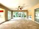 Bright sunroom with carpet, ceiling fan, and multiple windows overlooking the yard at 16405 Sw 14Th Avenue Rd, Ocala, FL 34473