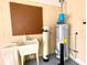 Utility area with water heater, water softener, utility sink, and pegboard at 16405 Sw 14Th Avenue Rd, Ocala, FL 34473