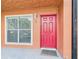 Inviting front entrance with bright red door, window, and clean facade creating a welcoming first impression at 1801 Caralee Blvd # 2, Orlando, FL 32822