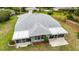 An aerial view highlighting the home's roof, enclosed patio, and landscaping at 19028 Sw 101 Pl, Dunnellon, FL 34432