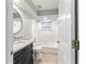 Bright bathroom featuring a tub/shower combo, stylish vanity, and modern fixtures at 19028 Sw 101 Pl, Dunnellon, FL 34432