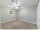 Bedroom featuring neutral carpeting, ceiling fan and window at 19028 Sw 101 Pl, Dunnellon, FL 34432