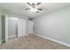 Bedroom featuring neutral carpeting, ceiling fan, and closet with open door at 19028 Sw 101 Pl, Dunnellon, FL 34432