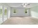 Bright and airy bedroom with neutral walls, ceiling fan, and french doors leading outside at 19028 Sw 101 Pl, Dunnellon, FL 34432