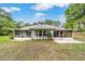 The back exterior of the home features an enclosed porch and patio at 19028 Sw 101 Pl, Dunnellon, FL 34432
