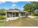 A view from the yard shows the screened porch, patio, and back of the house at 19028 Sw 101 Pl, Dunnellon, FL 34432