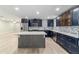 Spacious kitchen with blue cabinetry, a center island, stainless steel appliances, and tiled floors at 19028 Sw 101 Pl, Dunnellon, FL 34432