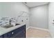 Functional laundry room with blue cabinetry, decorative backsplash, and tile flooring at 19028 Sw 101 Pl, Dunnellon, FL 34432