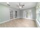 Open living room featuring wood look tile floors, ceiling fan, and glass paneled doors at 19028 Sw 101 Pl, Dunnellon, FL 34432