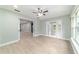 Open living room with wood look tile floors, ceiling fan, and natural light through glass doors at 19028 Sw 101 Pl, Dunnellon, FL 34432