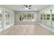 Relaxing sunroom featuring wood look tile floors, large windows, and a ceiling fan at 19028 Sw 101 Pl, Dunnellon, FL 34432
