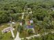 Aerial view of the home nestled in a lush, green neighborhood, showcasing its serene and private setting at 19370 Saint Benedict Dr, Dunnellon, FL 34432