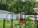 Backyard view featuring a shed, fencing, patio and lush landscaping at 19370 Saint Benedict Dr, Dunnellon, FL 34432