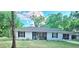 Charming single-story home with a well-manicured lawn, tidy landscaping, and a cheerful light-blue front door at 19370 Saint Benedict Dr, Dunnellon, FL 34432
