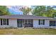 Inviting front yard with cozy chairs, decorative flowers, and charming touches, showcasing the home's curb appeal at 19370 Saint Benedict Dr, Dunnellon, FL 34432