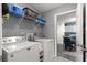 Bright laundry room features a Maytag washer and dryer, storage shelf, and view to the kitchen at 19370 Saint Benedict Dr, Dunnellon, FL 34432