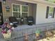 Cozy front porch features comfortable chairs, decorative flower arrangements, and a welcoming entrance to the home at 19370 Saint Benedict Dr, Dunnellon, FL 34432