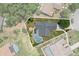 Aerial view of a home and lot with screened pool and fire pit surrounded by lush greenery and neighboring houses at 19942 Sw 96Th Pl, Dunnellon, FL 34432