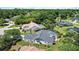 An aerial view showcases a home with a screened-in pool surrounded by mature trees and well-maintained lawns at 19942 Sw 96Th Pl, Dunnellon, FL 34432