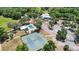 Aerial view of tennis courts, a pool, clubhouse, and parking within a wooded community at 19942 Sw 96Th Pl, Dunnellon, FL 34432