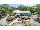 Aerial view of a light blue community building with lush landscaping and ample parking at 19942 Sw 96Th Pl, Dunnellon, FL 34432