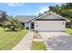 Charming single-story home with a well-manicured lawn, attached garage, and a welcoming walkway at 19942 Sw 96Th Pl, Dunnellon, FL 34432