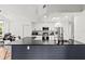 Modern kitchen boasts stainless steel appliances, black countertops, and a spacious island with breakfast bar seating at 19942 Sw 96Th Pl, Dunnellon, FL 34432