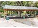 Covered picnic shelter with tables and views of a waterfront area in the distance at 19942 Sw 96Th Pl, Dunnellon, FL 34432