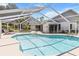 Inviting screened-in pool area featuring a sparkling pool, lounge chairs, and a spacious deck at 19942 Sw 96Th Pl, Dunnellon, FL 34432