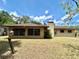View of the backyard with windows, a brick chimney and expansive lawn at 20100 Sw 95 St, Dunnellon, FL 34431