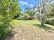 Exterior view of the home from the yard, with mature trees and an expansive lawn at 20100 Sw 95 St, Dunnellon, FL 34431