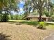 Sprawling front yard features a well-maintained lawn with mature trees and landscaping at 20100 Sw 95 St, Dunnellon, FL 34431