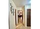 Hallway leading to a bedroom with tiled floors and decorative wall art at 20100 Sw 95 St, Dunnellon, FL 34431