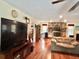 Bright living room features laminate flooring, fireplace and large television set at 20100 Sw 95 St, Dunnellon, FL 34431