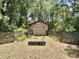 Backyard shed with a metal arbor and raised garden, surrounded by lush greenery at 20100 Sw 95 St, Dunnellon, FL 34431