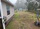 Backyard view in the rain with grass, utility shed, and chain link fence at 27 Cedar Tree Ter, Ocala, FL 34472