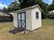Backyard outbuilding shed with painted blue trim and ramp for accessibility at 27 Cedar Tree Ter, Ocala, FL 34472
