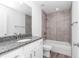 Bathroom featuring granite vanity top, a tub with tile surround, and modern fixtures at 3270 Sw 151St Ct, Ocala, FL 34481