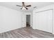 This bedroom features wood-look flooring, a ceiling fan and a closet at 3270 Sw 151St Ct, Ocala, FL 34481