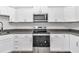 Close up of kitchen featuring stainless steel appliances, white cabinets, and granite countertops with wood floor at 3270 Sw 151St Ct, Ocala, FL 34481