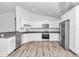 Bright kitchen features stainless steel appliances, white cabinets, granite counters, and modern wood flooring at 3270 Sw 151St Ct, Ocala, FL 34481