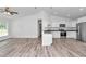 Bright open kitchen with stainless steel appliances, white cabinets, and granite countertops, hardwood floors at 3270 Sw 151St Ct, Ocala, FL 34481