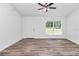 Bright living room with hard wood floors, a white door, and a window overlooking a green yard at 3270 Sw 151St Ct, Ocala, FL 34481