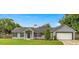 Charming single-story home featuring a gray exterior, attached garage, manicured lawn, and a traditional architectural style at 380 Ne 53Rd St, Ocala, FL 34479