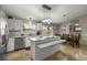 Bright eat-in kitchen featuring white cabinets, stainless steel appliances, granite countertops, and modern pendant lighting at 380 Ne 53Rd St, Ocala, FL 34479